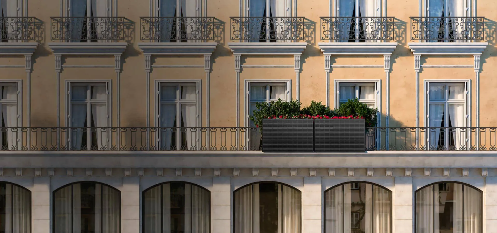 Prédio amarelo com varandas em que algumas estão decoradas com flores.