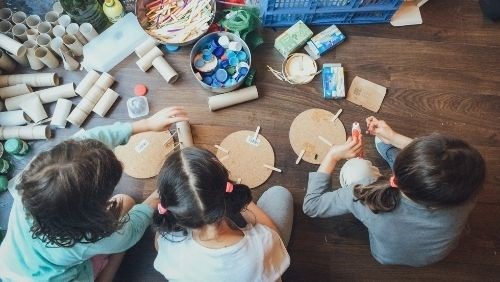 Crianças a brincar a aprender com material reciclado