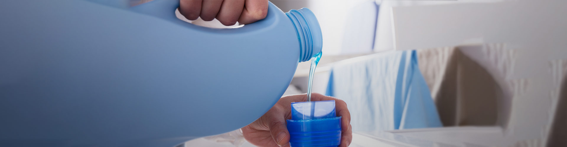 Detergente da máquina de lavar roupa a ser debitado para o copo de medida