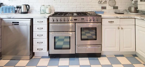 Cozinha onde se pode ver um fogão e uma máquina de lavar loiça