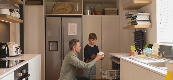 Pai e filho a arrumarem loiça numa cozinha
